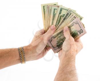 Stack of fifty and twenty US dollar bills being held by pair of senior caucasian hands as though offering as a gift