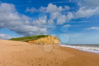 Wide beach underneath Jurassic Coast cliffs and headland at West Bay in Dorset used as the location for the Broadchurch TV series