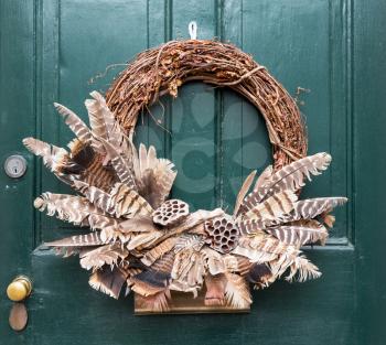 Traditional design of a christmas wreath attached to the front door of old house