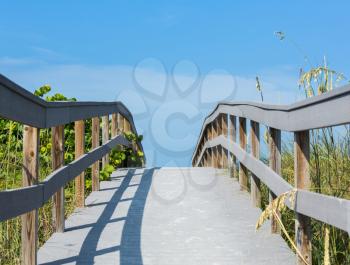 Wooden boardwalk to ocean amond sea oats on Sunset Beach at southern tip of Treasure Island Florida on Gulf of Mexico