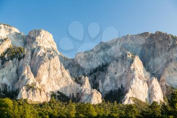 Steep jagged spikes of  chalk white cliffs of Mount Princeton near Buena Vista in Colorado shortly after sunrise as the sun first lights the mountainside