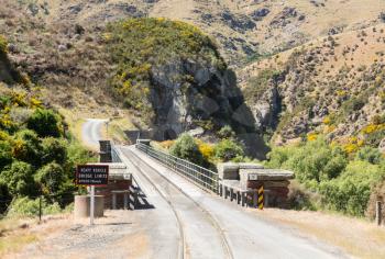 Railway track of Taieri Gorge tourist railway shares a road bridge across a ravine on its journey up the valley