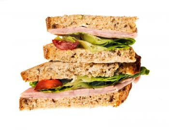 Isolated image of an english ham lettuce and tomato sandwich with a second one stacked on top. Bread is artisan multigrain wheat.