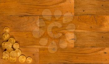 Wooden background of table with gold eagle coins in the corner to make a design for website with copy space