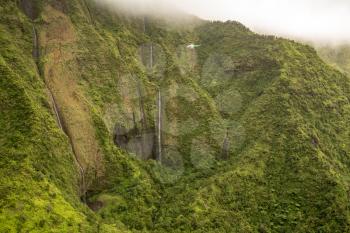 Aerial view of waterfalls in crater of Mount Waialeale on hawaiian island of Kauai from helicopter flight
