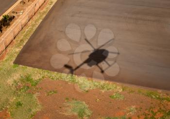 Shadow of small Hughes helicopter landing at Lihue in Kauai