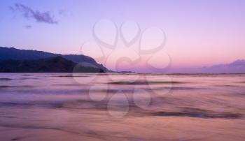 Sunrise lights the dawn sky above Hanalei Bay with the Na Pali coast in the background near Hanalei, Kauai, Hawaii