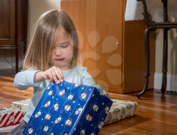 Young female toddler girl at Christmas opening presents and gifts