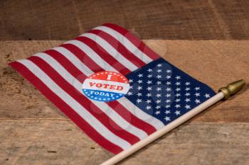 I Voted Today sticker  for voters in the US elections with USA flag on rustic wooden table