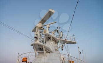 Navigation and radar equipment and antenna on the mast of cruise ship at dawn