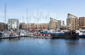 LONDON, UK - JANUARY 30, 2016: Docklands Light Railway train runs past the apartment buildings around Limehouse Basin Marina in Docklands, London, England