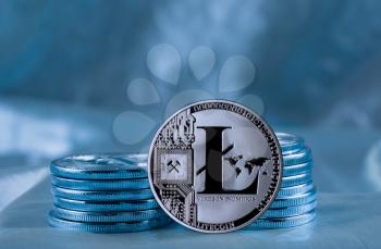 Stack of Litecoin coins on blue background to illustrate blockchain and cyber currency
