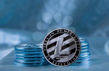 Stack of Litecoin coins on blue background to illustrate blockchain and cyber currency