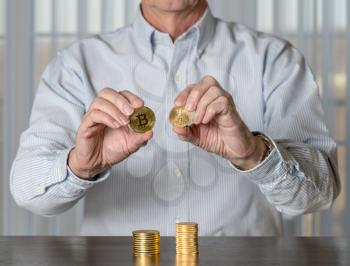 Senior man holding gold coins alongside stack of bitcoins to illustrate investment choice