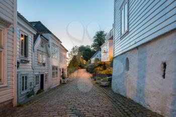 Narrow cobbestone Nedre Strangehagen Street at dusk in the old town of Bergen in Norway