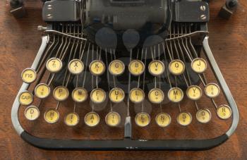 Old vintage portable typewriter with non qwerty type keys on wooden desk