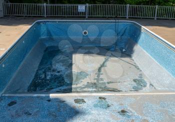Empty in ground swimming pool ready for replacement of old vinyl lining or liner