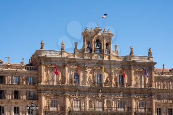 Flags fly over the windows of City Hall and clock tower in Plaza Mayor in Salamanca, Spain