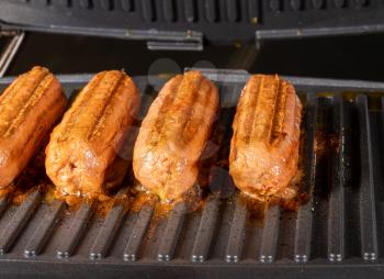 Plant-based vegetarian Sausages being grilled on griddle