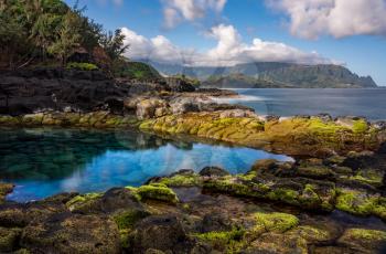 Long exposure of the calm waters of Queen's Bath, a rock pool off Princeville on north shore of Kauai