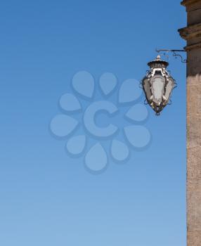 Details of the ornate wall lamp against clear blue sky with copy space