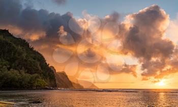 Sunset lights the receding cliffs of the NaPali coastline on north coast of Kauai in Hawaii