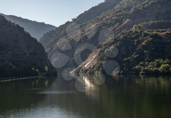 River Douro flowing through narrow gorge with rocky slopes on the banks in Portugal near Pinhao