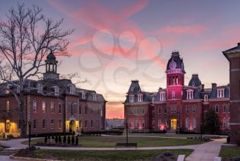 Dramatic image of Woodburn Hall at West Virginia University or WVU in Morgantown WV as the sun sets behind the illuminated historic building