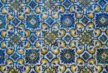 Pattern of blue and yellow old azulejo tiling on wall in traditional Portuguese style