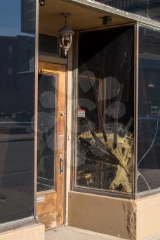 Cracked glass window pane by shop door looking like rioters have tried to enter the store