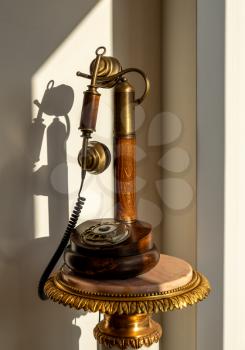 Antique traditional polished wood telephone and handset on marble table