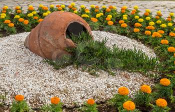 Flowers and gravel surround ceramic urn in ornamental garden