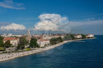 Tourists on the steps of Sea Organ along the promenande by the port of Zadar in Croatia