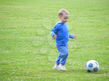 A child and a soccer ball. The kid wants to be a footballer.