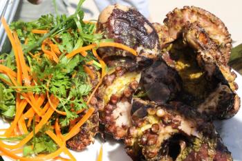 Grilled octopus with vegetables and seafood. Cooking seafood in the open air