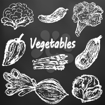 Child drawing with white chalk on a black board. Tasty vegetables. Useful pictures. Cauliflower, cucumber, broccoli, bell pepper, eggplant, white cabbage, beetroot