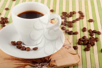  white coffee cup, dish and coffee beans  on green bamboo stand