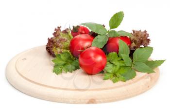 fresh red tomatoes and greens on white background