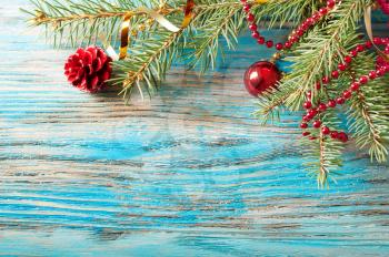 Red Christmas decorations and fir branch on a wooden background