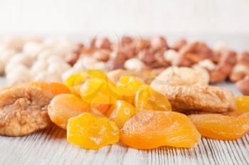 Dried fruits and nuts on a wooden background. Candied fruits, lemon, apricot, fig and nuts. 