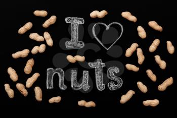 Peanuts on a black background and chalk inscription I love nuts