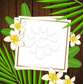 Decorative floral frame with tropical flowers and leaves on a wooden background