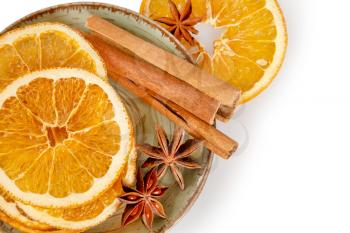 Dried orange slices, cinnamon and star anise in a plate. Spices for mulled wine on a white background.