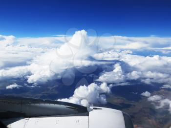 Wing of the plane on blue sky and clouds background
