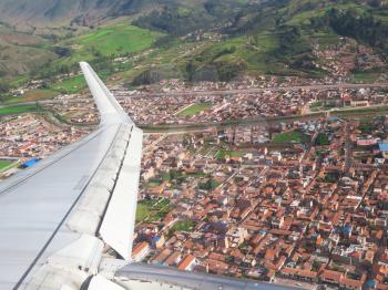 Wing of the plane on Cuzco city and mountain background