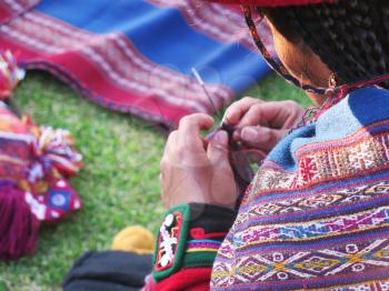 Close up of Peruvian lady in authentic dress spinning yarn by hand. (Peru)