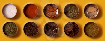Bright set of spices Asian and South American cuisine in metal cans on yellow background