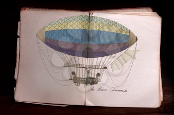 Tattered Old open book with color illustration dirigible