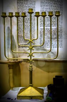 candlestick for nine candles on the background of the unfolded Tori for Hanukkah still life