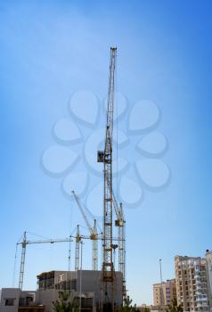 Several tower cranes build a mult storey house
